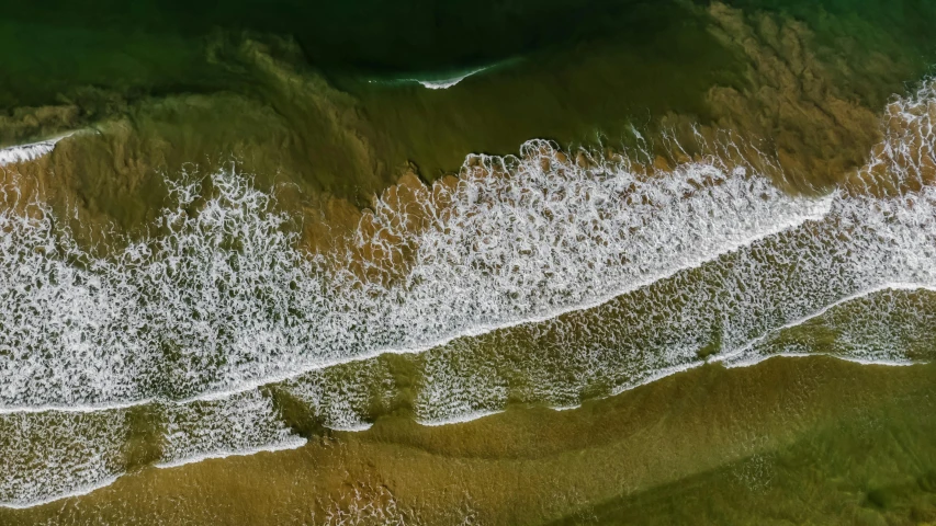 an aerial view of the sea water and shoreline