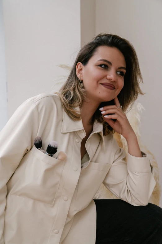 a women sitting wearing a white shirt with her hands on her chin