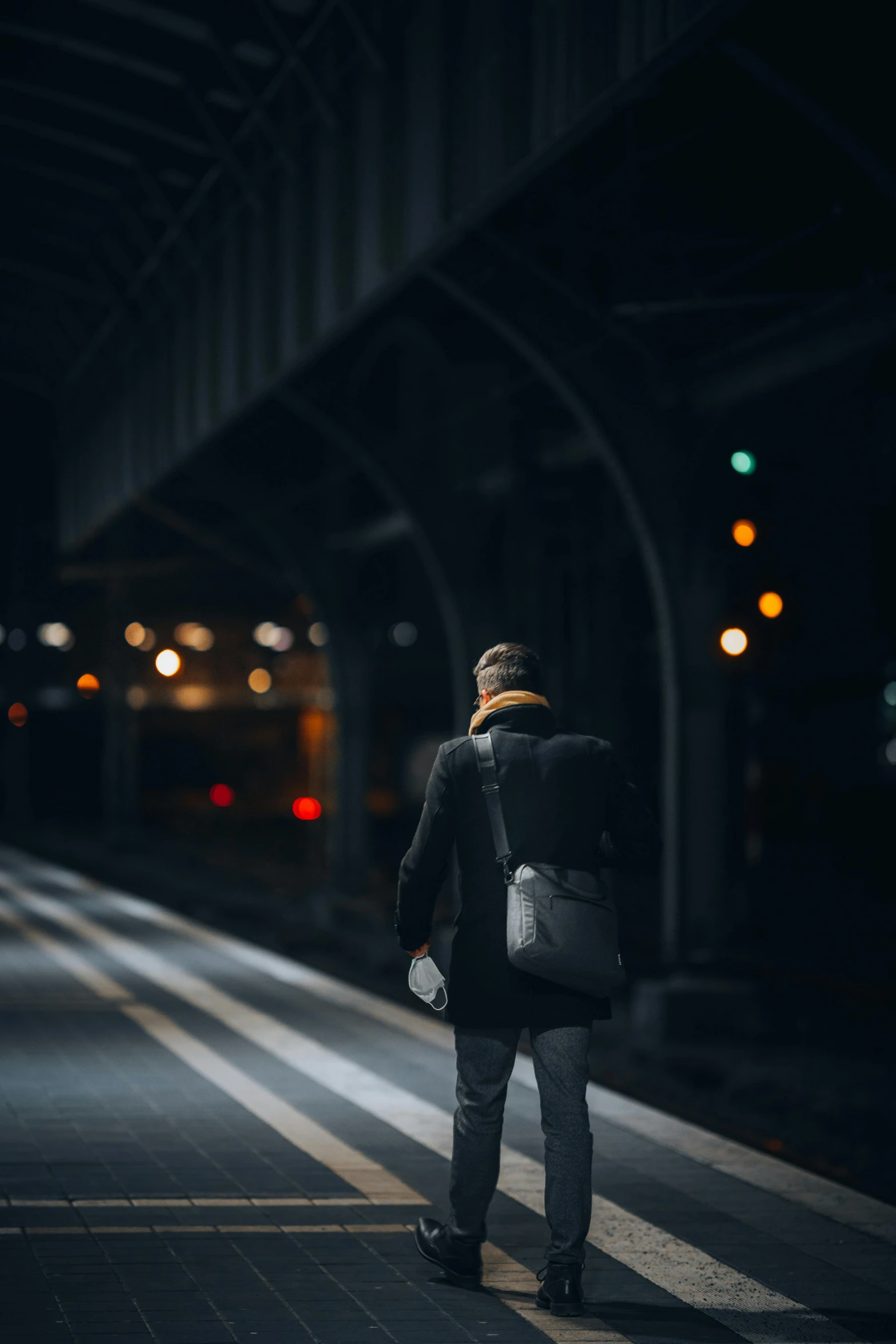 a person standing on a train platform waiting for the train