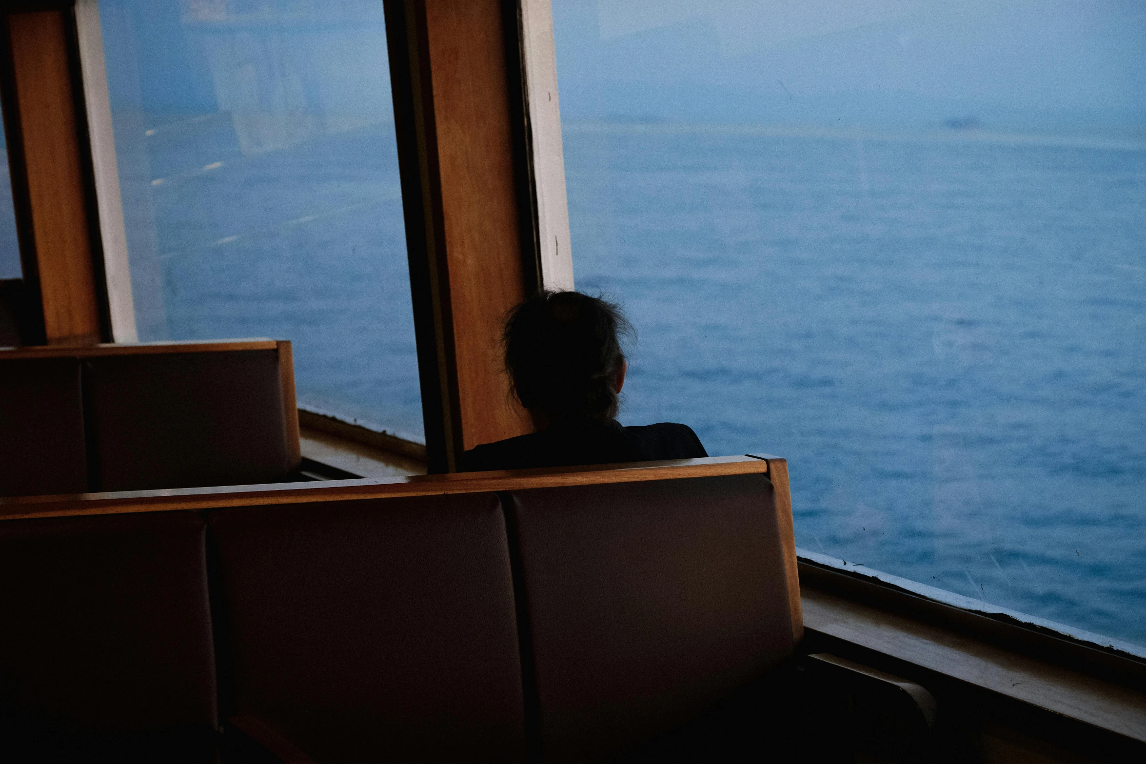 a woman looks out from a ferry window