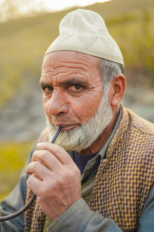 an old man is holding a pencil in his mouth