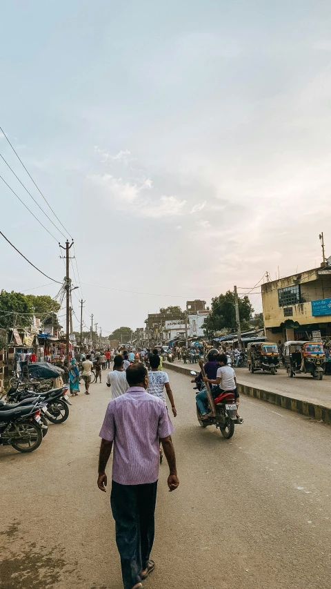 many people on motorcycles walking down the road