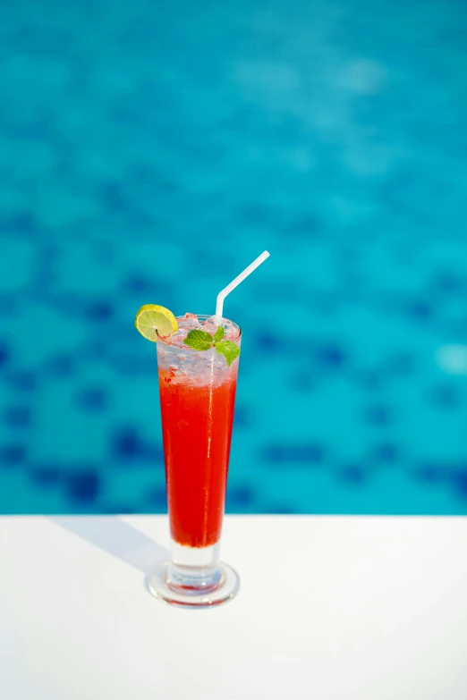 the red drink is on the side of a pool