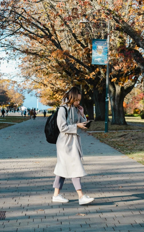 a woman walking down the street while using her phone