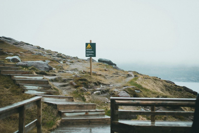 a steep hill with a sign warning of dangers for people on it