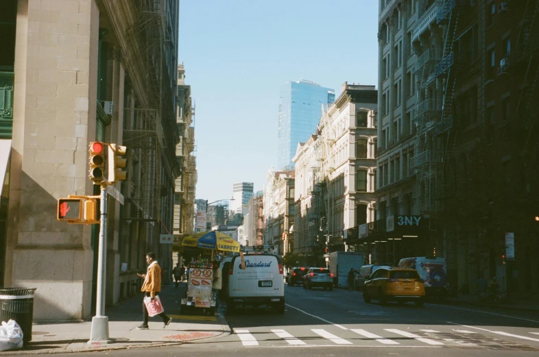 a busy street with cars, buildings and people walking down the street