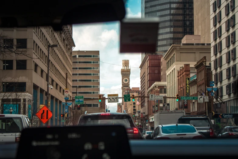 a busy city street and buildings are seen through a car window