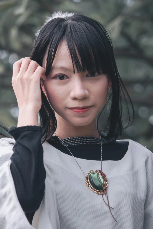 an oriental woman with short black hair and a white dress