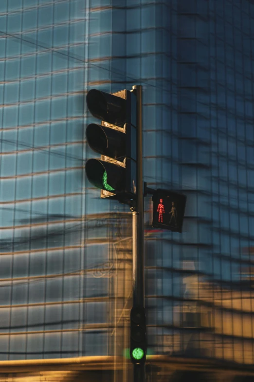 two traffic lights attached to a post next to a building