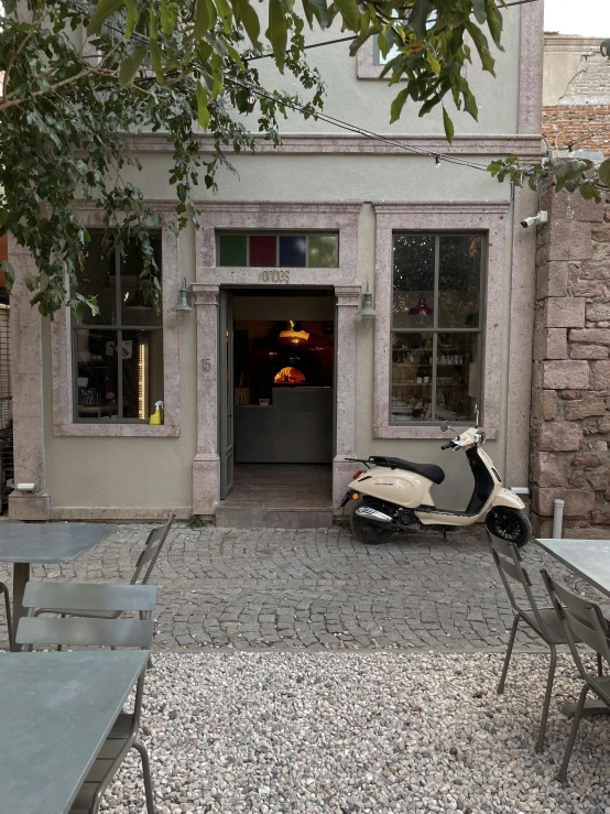 a scooter is parked outside a small store front