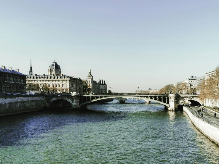 a view of a bridge across a river with buildings and clock tower on either side