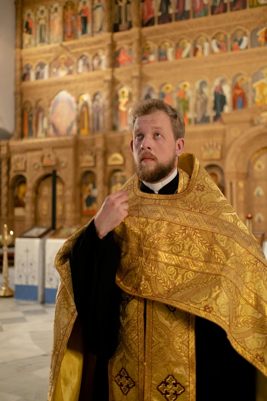 a man in a priest's outfit is holding the cross