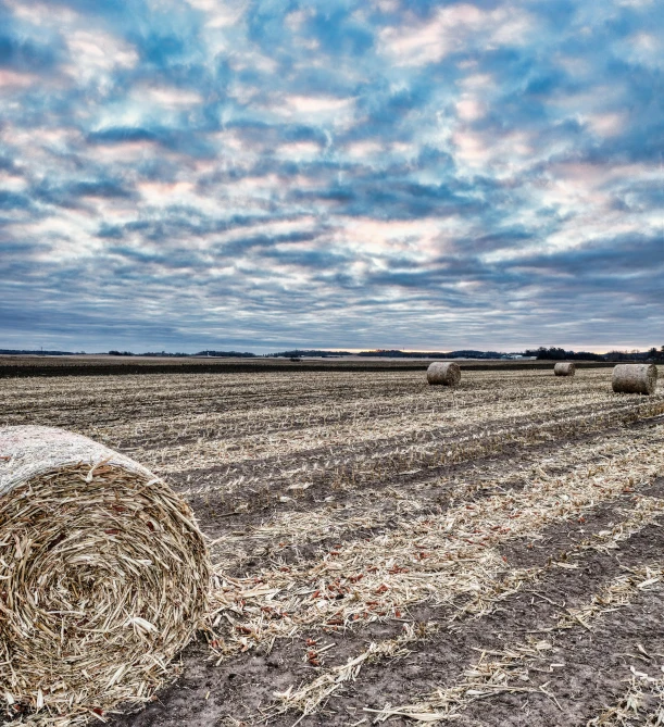 a hay bale sitting in a vast field