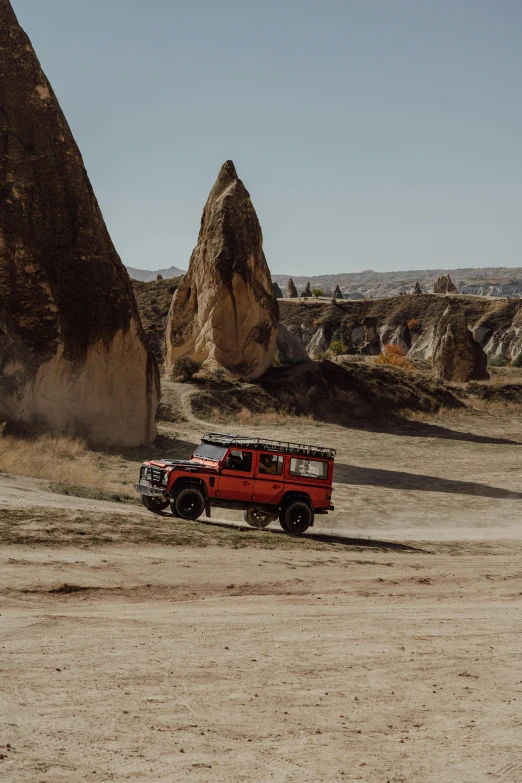 an off road jeep is parked near some big rocks