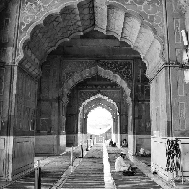 a man is sitting on the floor in a large archway