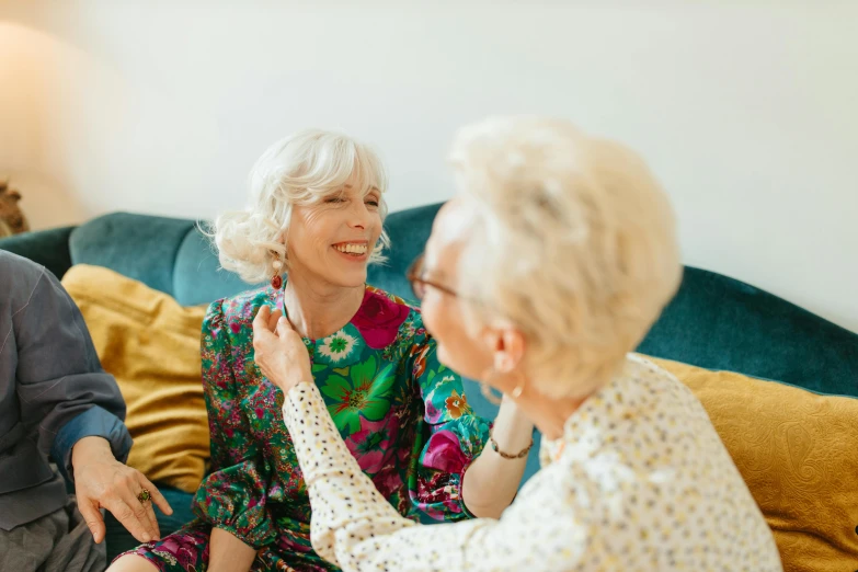 a woman helps an older woman put on her ear