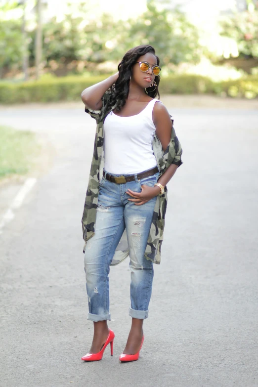 a woman standing on the street in her white shirt and jeans