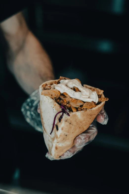 a person holding a food item on a table