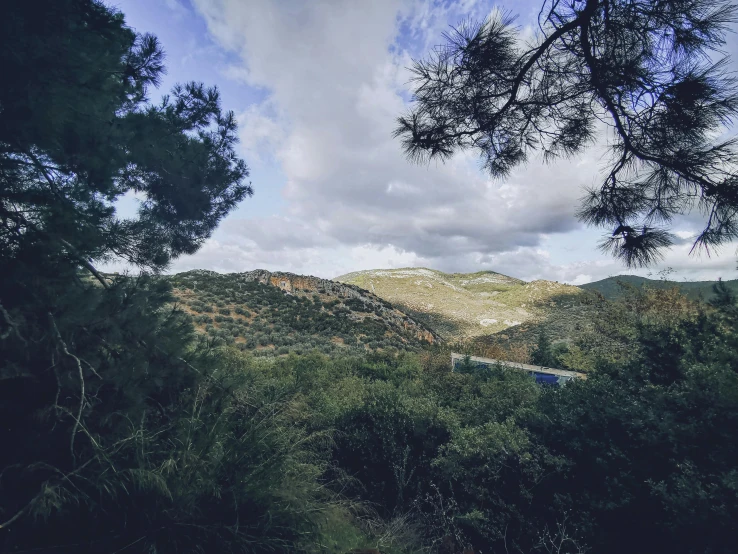 the view from the top of the mountain, with trees in front of it