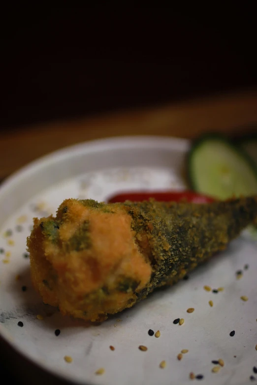 a food entree on a plate, with a side of cucumber slices