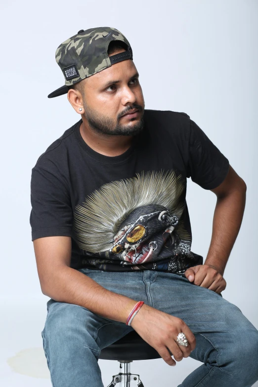 a man sitting on a stool looking to his left