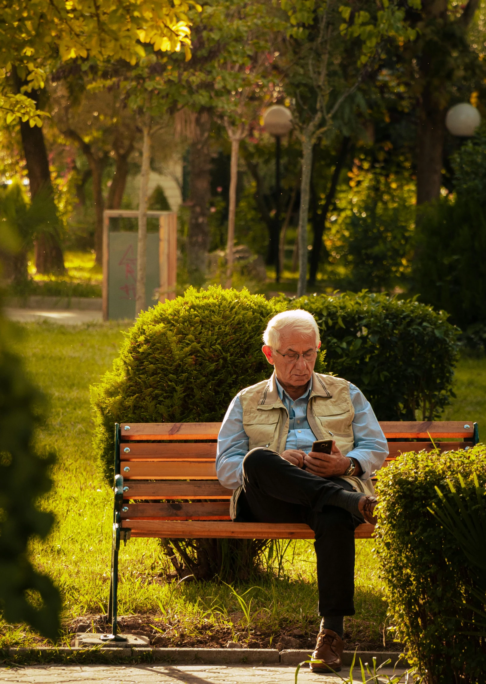 an elderly man sitting on top of a wooden bench