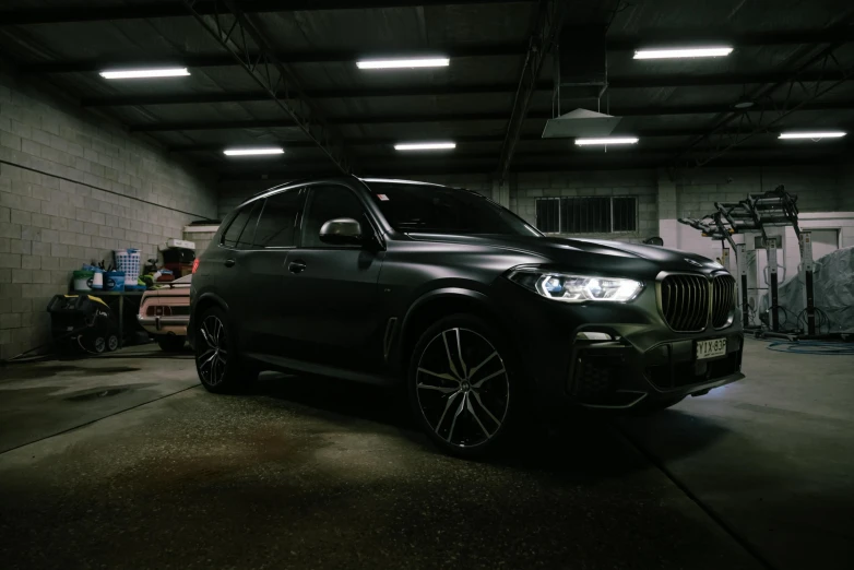 a big black bmw suv in a garage