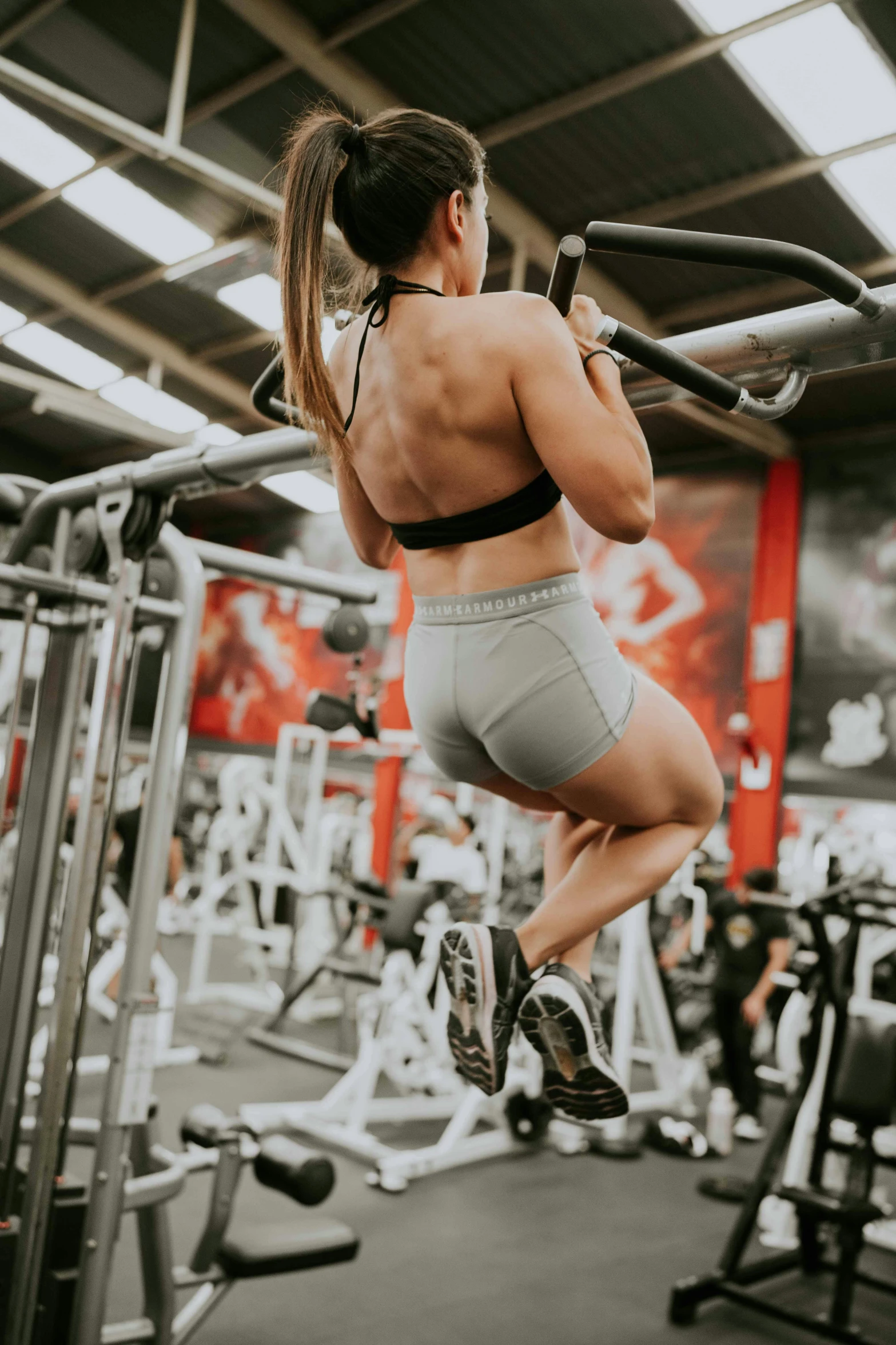 a woman jumping over a bar in a gym