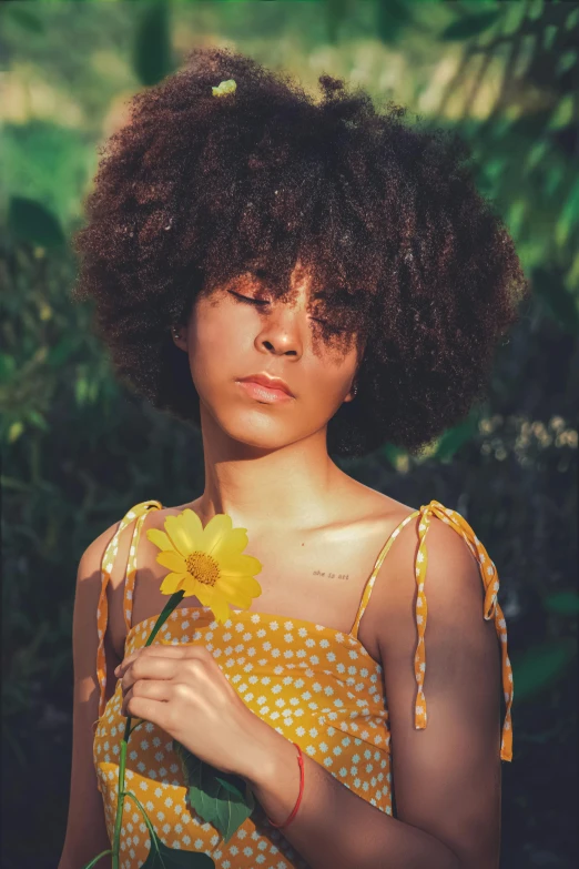 a close - up po of an african american woman holding a flower