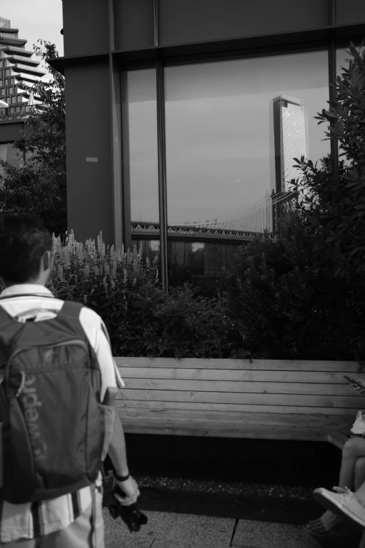 a black and white po of a man sitting on a park bench looking at his cell phone