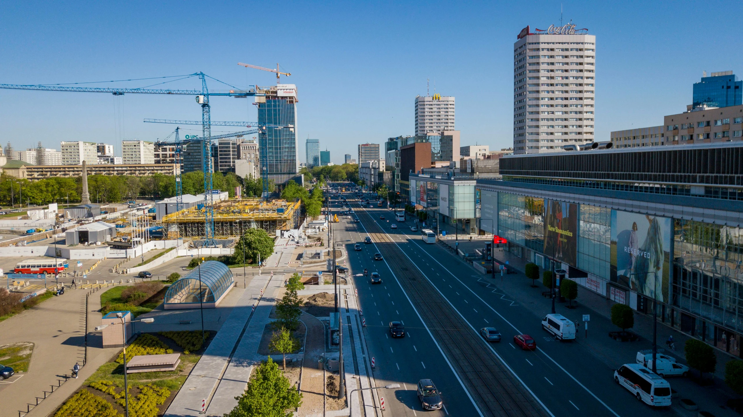 a city street with tall buildings on either side of the tracks