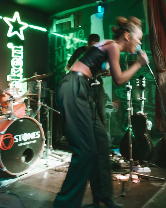 a woman is singing on stage at a concert