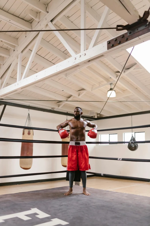 a person in a room that has some boxing rings hanging from the ceiling