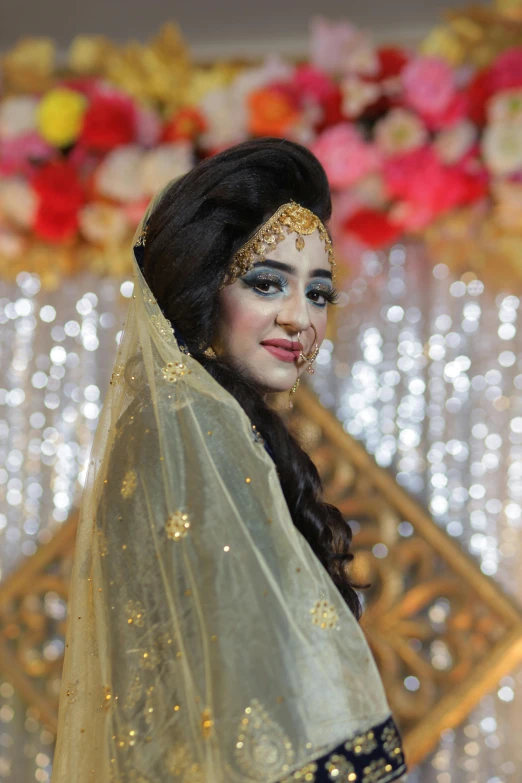 bride in white lehenga posing with gold and blue make - up