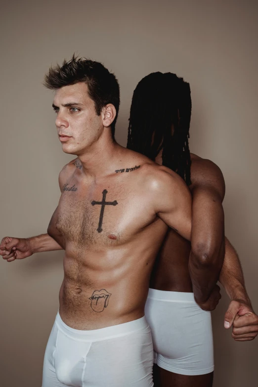 two men with cross tattooed on their chest