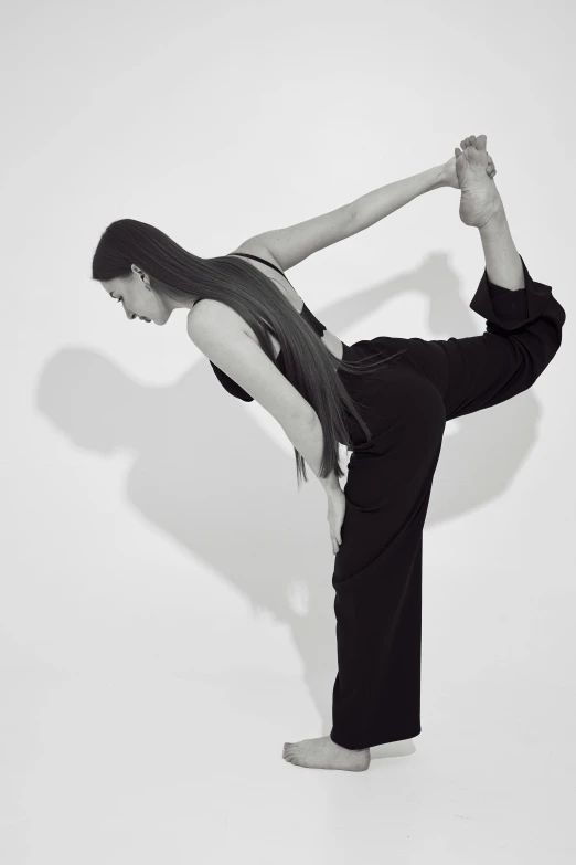a woman in black shirt doing a yoga pose