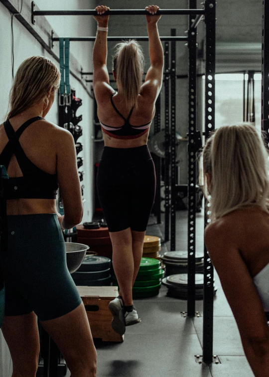 three women at the gym doing different things