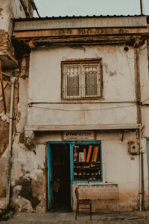 an old, run down white building with blue doors