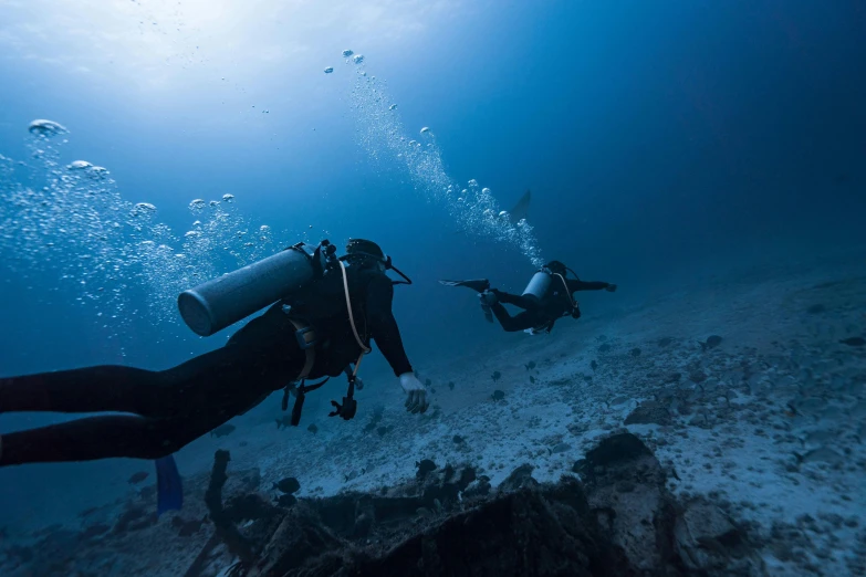 two divers in the ocean water underwater diving