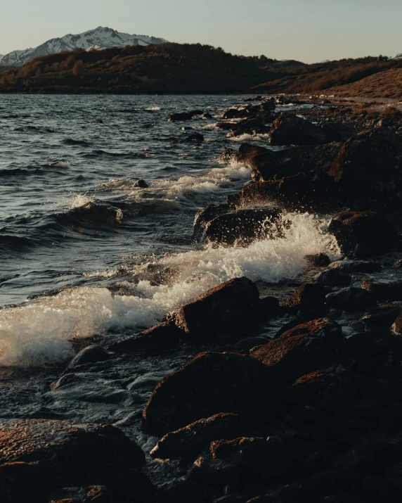 an ocean wave near a rocky shoreline