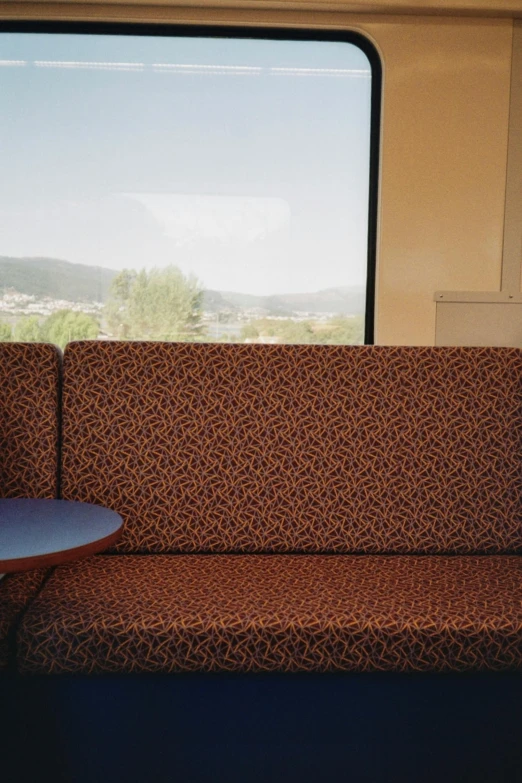 a seat and table in a train with open windows