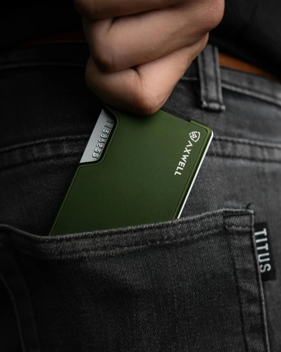 a hand holding an apple credit card on the pocket of a pair of jeans