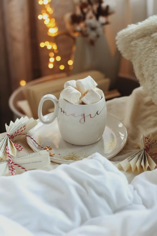 a white coffee mug on a plate next to some cookies