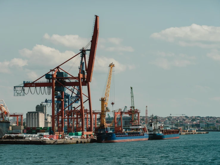 a large cargo ship at dock with other ships in the background