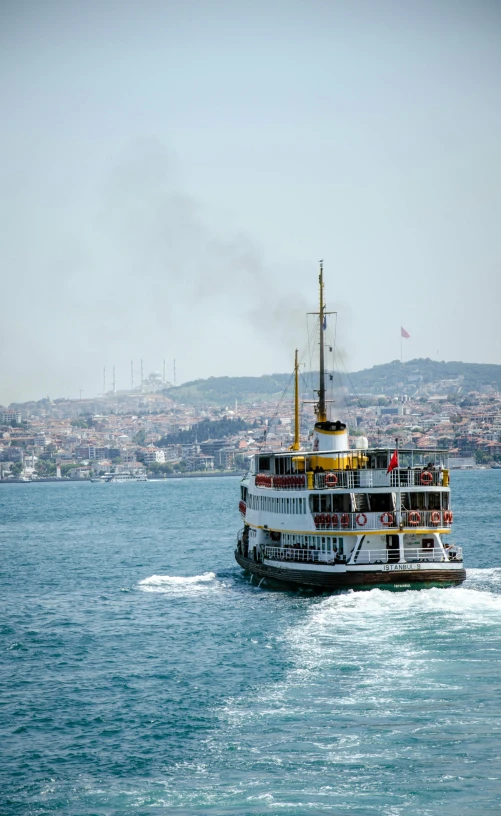 a boat moving in front of a city on a river