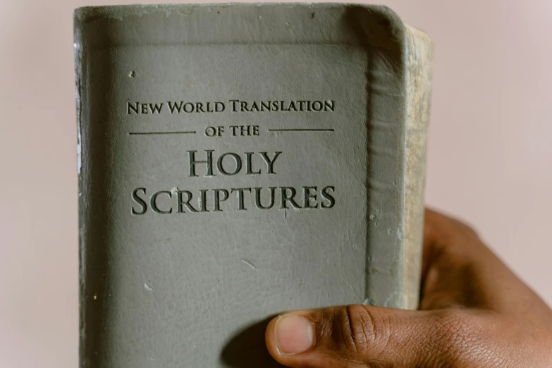 hand holding old holy book with new world translation
