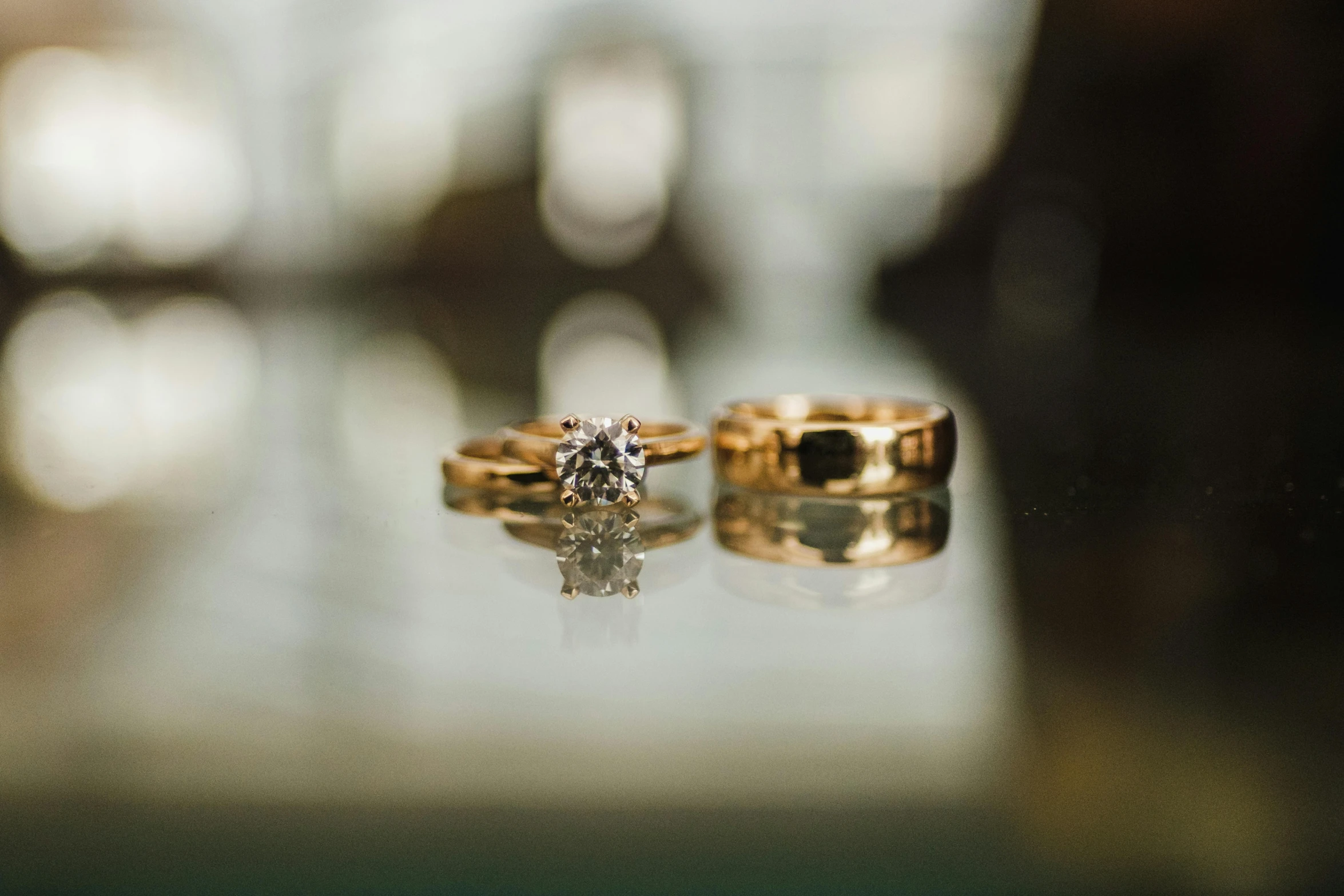 an engagement ring sitting next to an engagement ring in the reflection