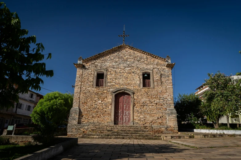 a tall brick building has two doors and two crosses on it