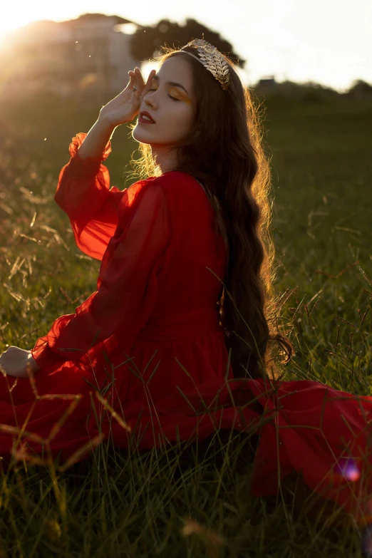 a beautiful woman sitting in the middle of a field