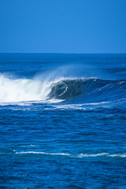 a large wave with a surfer standing in the ocean